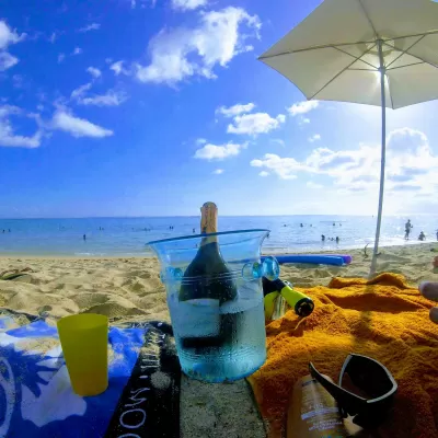 Why Should You Take Your Own Towels While Traveling? : Using own towels to drink pineapple champagne on a public sand beach in Tahiti, French Polynesia